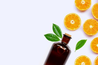 Beyaz arka planda gerekli yağ şişesiyle taze portakal meyvesi..