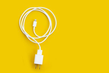 Sarı arkaplanda cep telefonu şarjı..