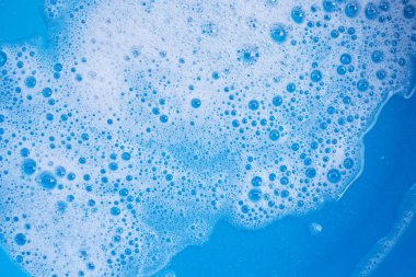 Deterjan köpüğü mavi arka planda. Üst görünüm