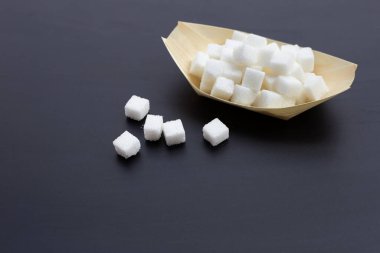 Koyu arkaplanda küp şeker. Boşluğu kopyala