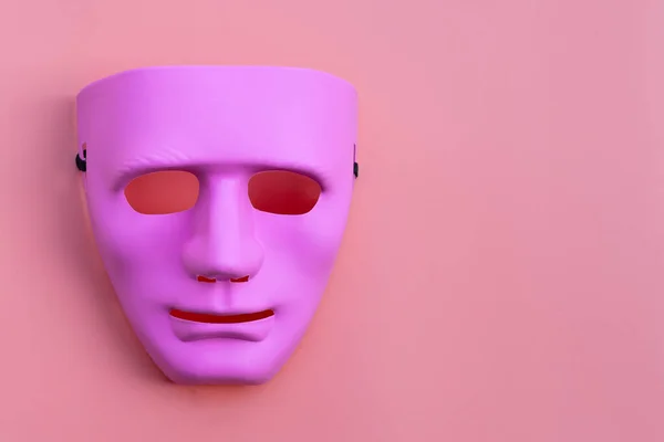 Pink face mask on pink background. Copy space