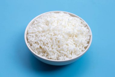 Mavi arka planda beyaz kase pirinç..