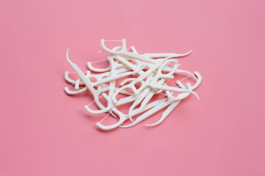 Pembe arka planda beyaz diş ipi kürdanları. Boşluğu kopyala
