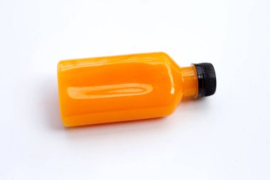 Beyaz arka planda plastik şişede portakal suyu. 