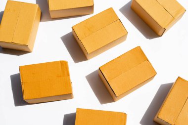 Beyaz arkaplanda kahverengi karton kutular.