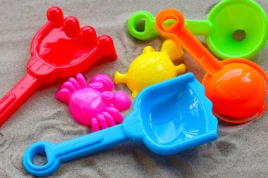 Plastik oyuncaklar, renkli kürekler, kumdaki kumlar. Yaz arkaplanı kavramı