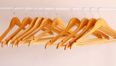 Boş ahşap kıyafetler alüminyum korkuluklara asılıyor. 