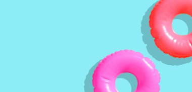 Mavi arka planda şişme yüzme havuzu halkaları.