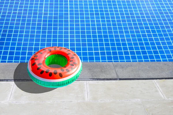 Watermelon rubber ring for swimming on cement floor of the swimming pool. Summer background concept