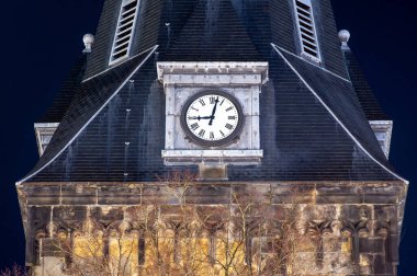 Hollanda 'nın Enschede kentindeki en eski kilisenin saati 21: 00' i gösteriyor. Covid-19 sırasında Hollanda 'da sokağa çıkma yasağı.