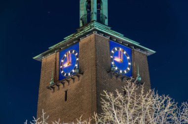 Hollanda 'daki Enschede belediye binasının saati 21: 00' i gösteriyor. Covid-19 sırasında Hollanda 'da sokağa çıkma yasağı.