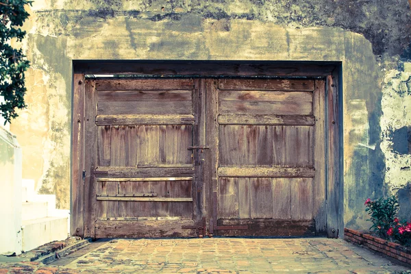 Oude houten deur op de muur — Stockfoto