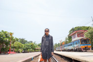 Asyalı genç güzel kız demiryoluna yürüyüş