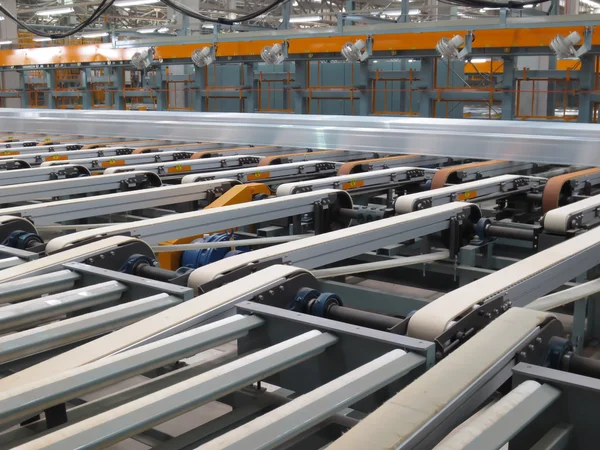 Linhas de alumínio em uma correia transportadora em uma fábrica . — Fotografia de Stock