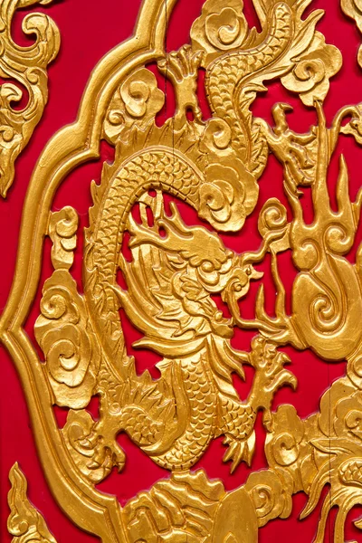 Dragon doré décoré sur un mur en bois rouge — Photo