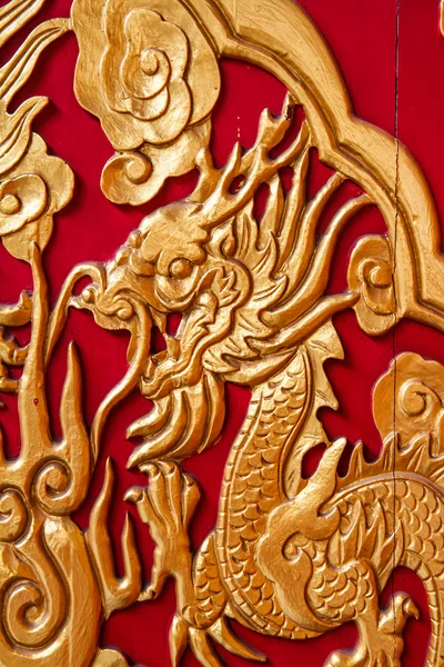 Dragon doré décoré sur un mur en bois rouge — Photo