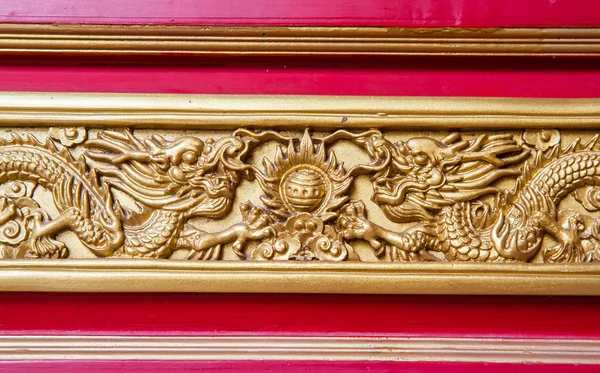 Dragon doré décoré sur un mur en bois rouge — Photo