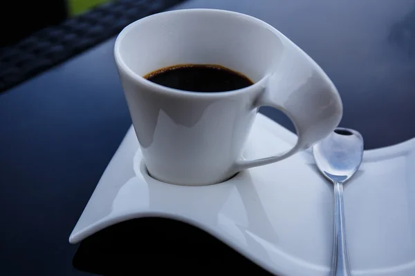 Tasse schwarzen Kaffee auf einem schwarzen Tisch. — Stockfoto