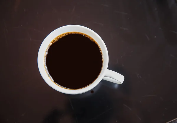 Cup of black coffee on a black table. — Stock Photo, Image