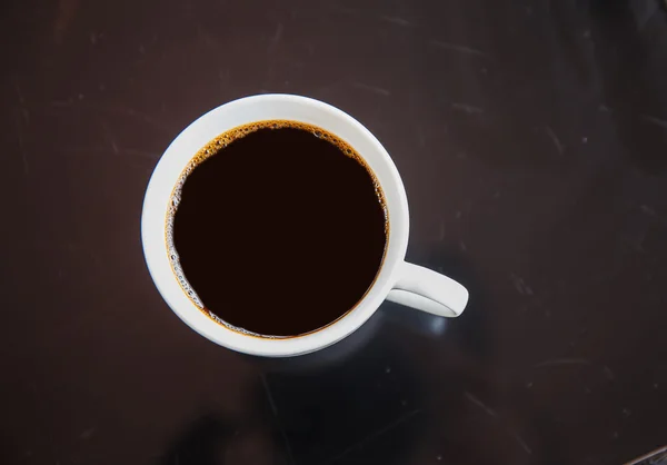 Xícara de café preto em uma mesa preta . — Fotografia de Stock