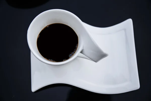 Xícara de café preto em uma mesa preta . — Fotografia de Stock