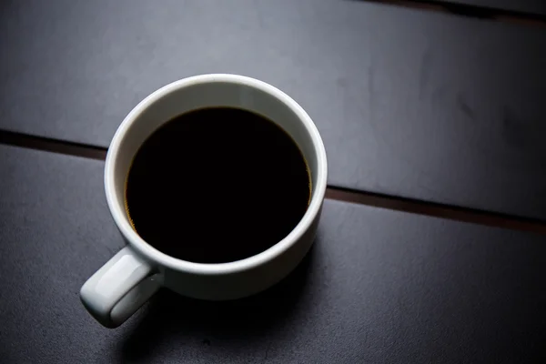 在黑色的桌子上的咖啡杯 — ストック写真