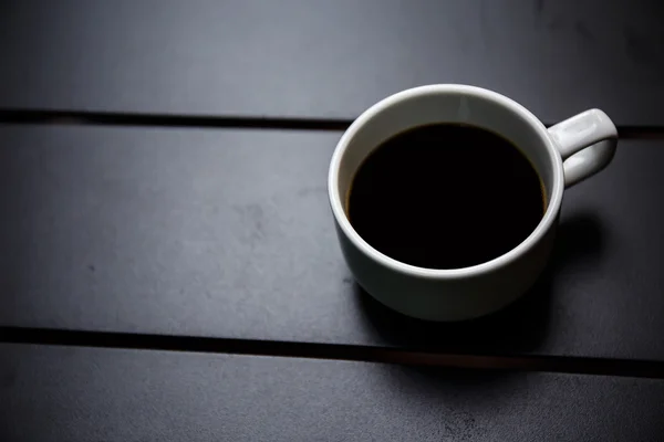 在黑色的桌子上的咖啡杯 — ストック写真
