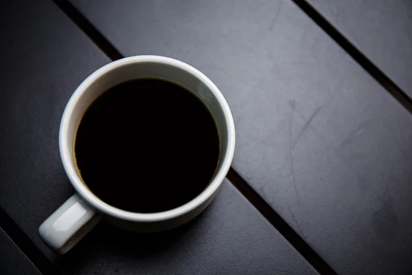 Kaffeetasse auf schwarzem Tisch — Stockfoto