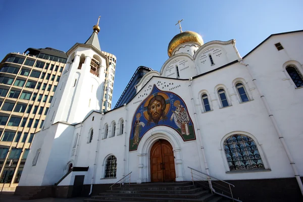 The old Church with a bell tower and a modern building — Stock Photo, Image