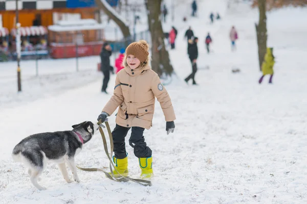 Niño con su perro en la nieve — Foto de Stock