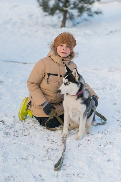 Ragazzo con il suo cane nella neve — Foto Stock