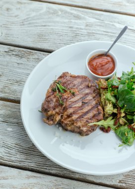 bir tabak biftek ve ızgara sebzeler