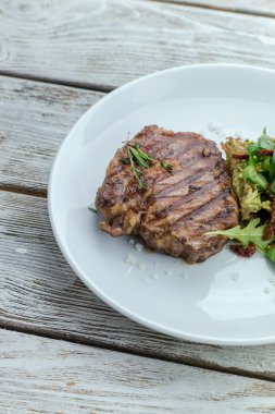 bir tabak biftek ve ızgara sebzeler