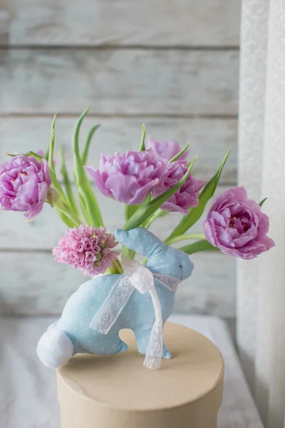 Vaso com um buquê de tulipas e um coelho de um tecido — Fotografia de Stock