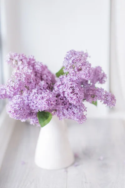 Un bouquet de lilas dans un vase blanc — Photo