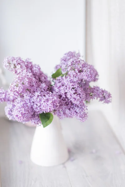 Um buquê de lilás em um vaso branco — Fotografia de Stock