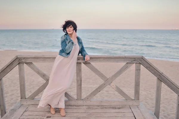 Chica en la chaqueta de mezclilla junto al mar — Foto de Stock