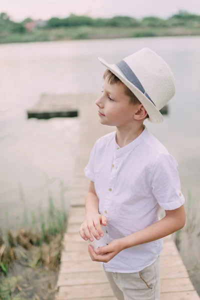 Pojke i hatt nära floden — Stockfoto