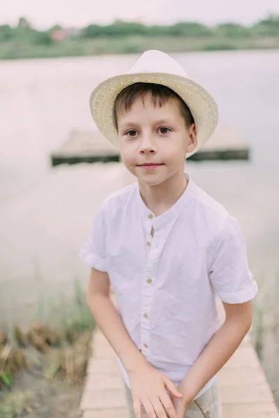 Menino de chapéu perto do rio — Fotografia de Stock