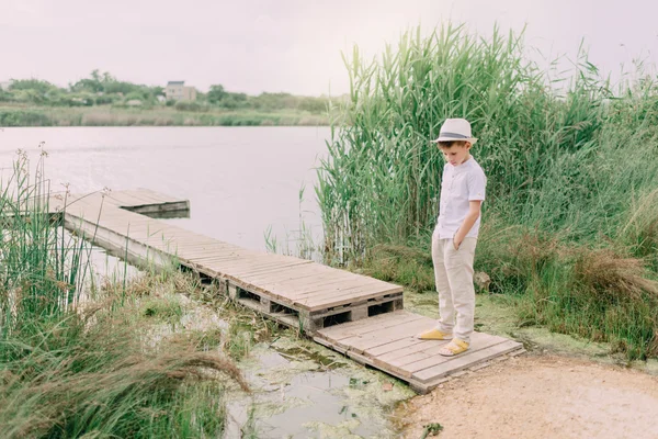 Niño junto al río y caña — Foto de Stock