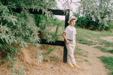 bir kitapla şapkalı çocuk