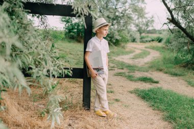 bir kitapla şapkalı çocuk