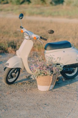 Beyaz moped ve çiçek sepeti