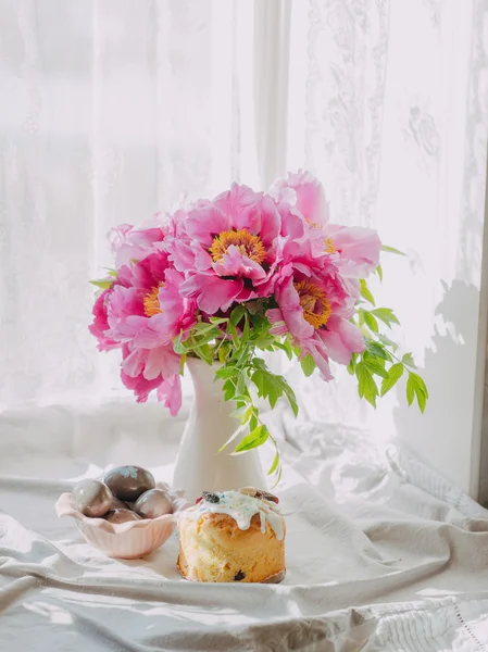 Strauß rosa Pfingstrosen und Osterkuchen mit Eiern — Stockfoto