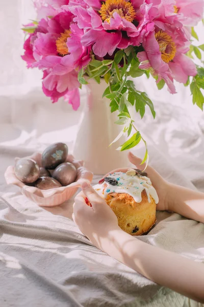 Bukett med rosa pioner och påsk kaka med ägg — Stockfoto