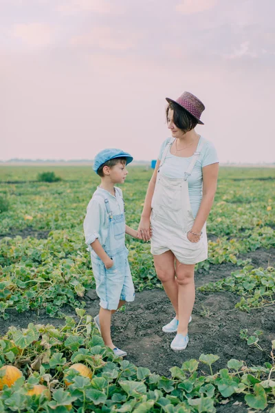 Mutter und Sohn auf einem Feld mit Melonen — Stockfoto