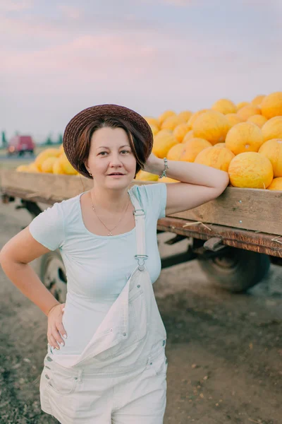 Mujer tienen carros con melones amarillos maduros — Foto de Stock