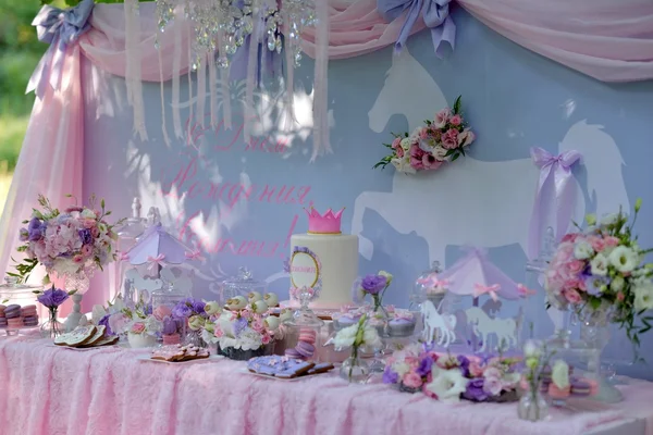 Mesa con flores y un postre — Foto de Stock