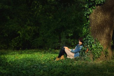 Bir ağacın altında oturan kadın