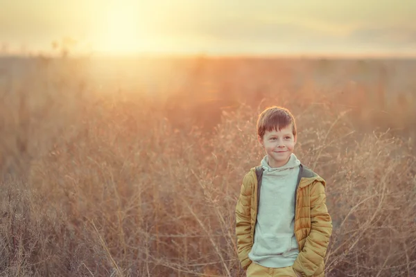 Мальчик на осеннем поле — стоковое фото